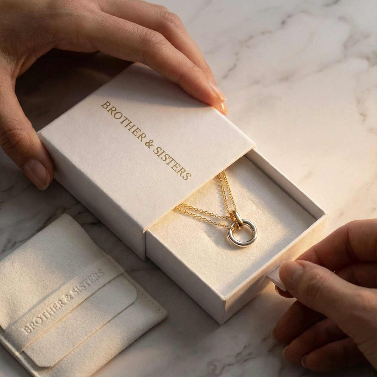 The Unity Bond necklace by Brother & Sisters in elegant packaging, showcasing mixed metal design.