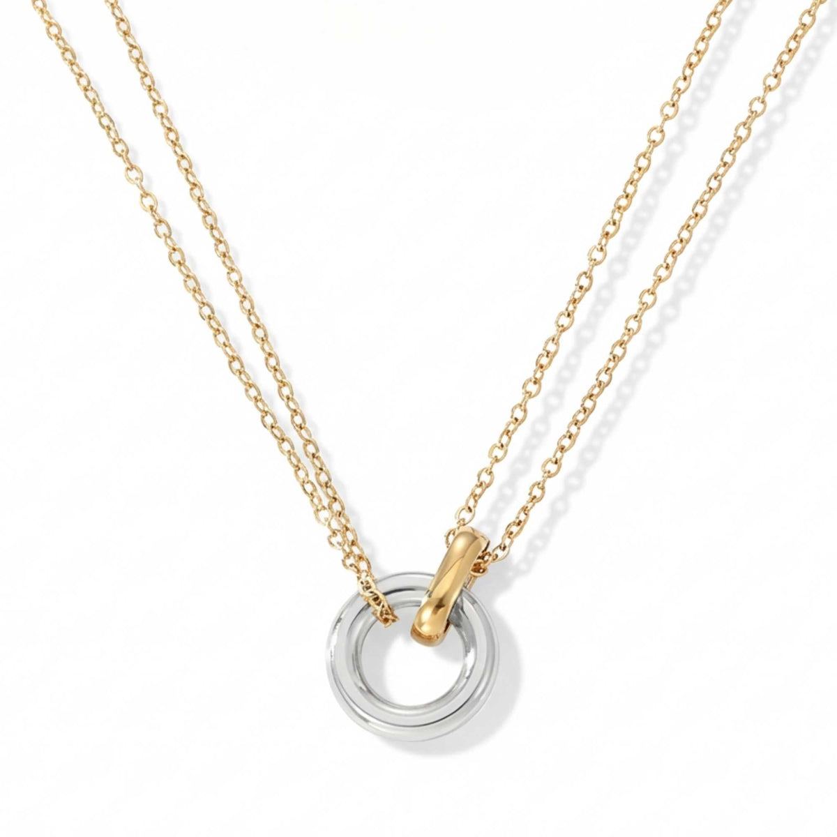 The Unity Bond necklace by Brother & Sisters features a silver circle and gold bar pendant.