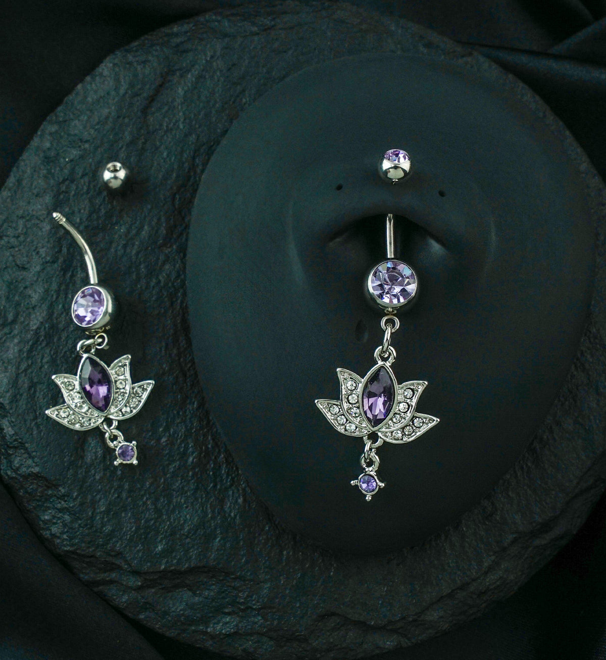 Lotus Flower Purple Gem Belly Ring, shown on a display torso with a second ring beside it