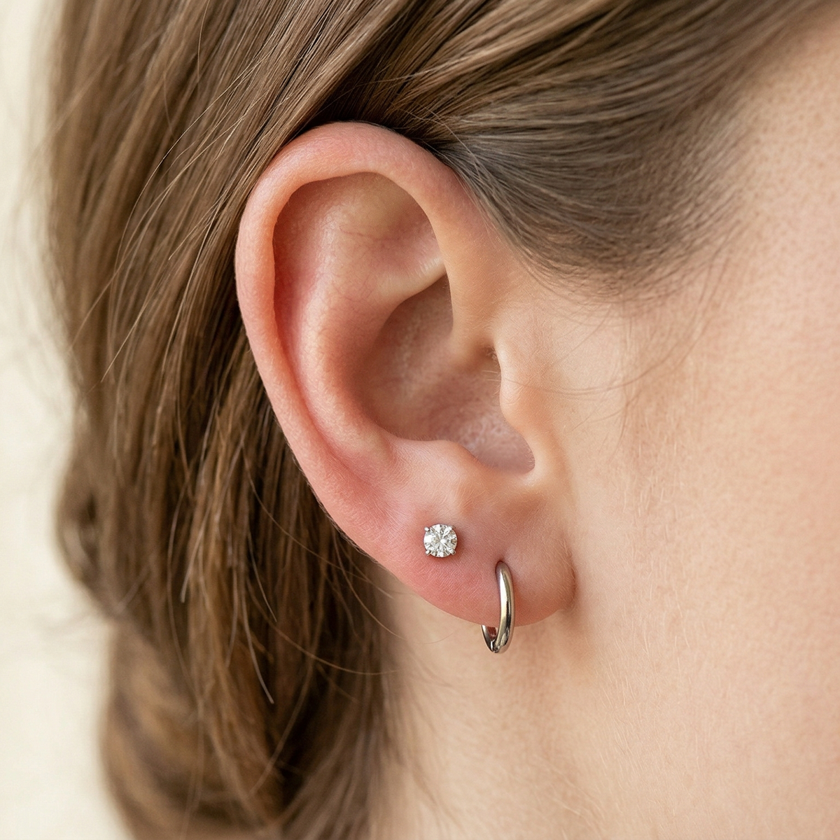 Silver titanium clear CZ stud earring shown on ear with lobe piercing