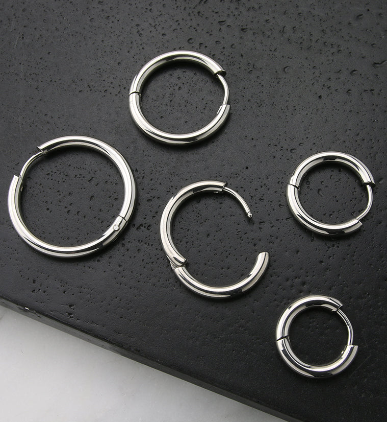 Stainless Steel Hinged Hoop Earrings, five sizes shown open and closed on black stone